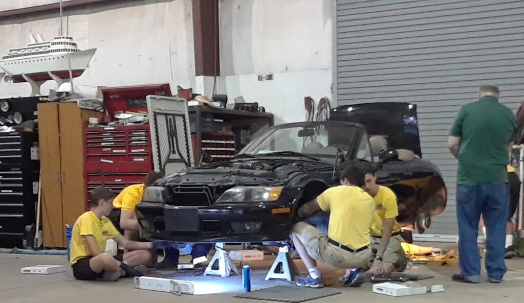A Group Of People Working On A Car